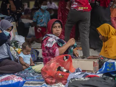Warga terdampak letusan gunung Semeru mengungsi di tempat penampungan sementara di desa Sumber Wuluh di Lumajang, Jawa Timur, Senin (6/12/2021). Berdasarkan laporan Posko Tanggap Darurat Bencana Gunung Semeru erupsi, total korban jiwa ada sebanyak 15 orang meninggal dunia. (Juni Kriswanto/AFP)