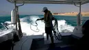 Seorang pelaut mengumpulkan tali jangkarnya setelah menyelam di Laut Merah, dekat King Abdullah Economic City, Arab Saudi. Pesona keindahan Laut Merah memikat pengunjung dari seluruh dunia. (AP Photo/Amr Nabil)