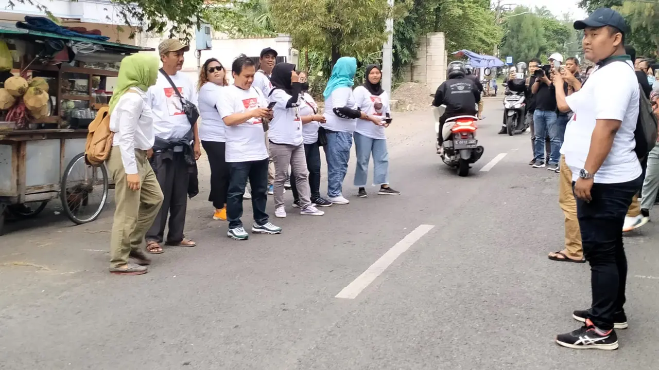 Relawan Tifosi Ganjar Pranowo (Tegap) membagikan atribut Ganjar Pranowo kepada pengguna jalan di kawasan Diponegoro  Surabaya. (Istimewa).