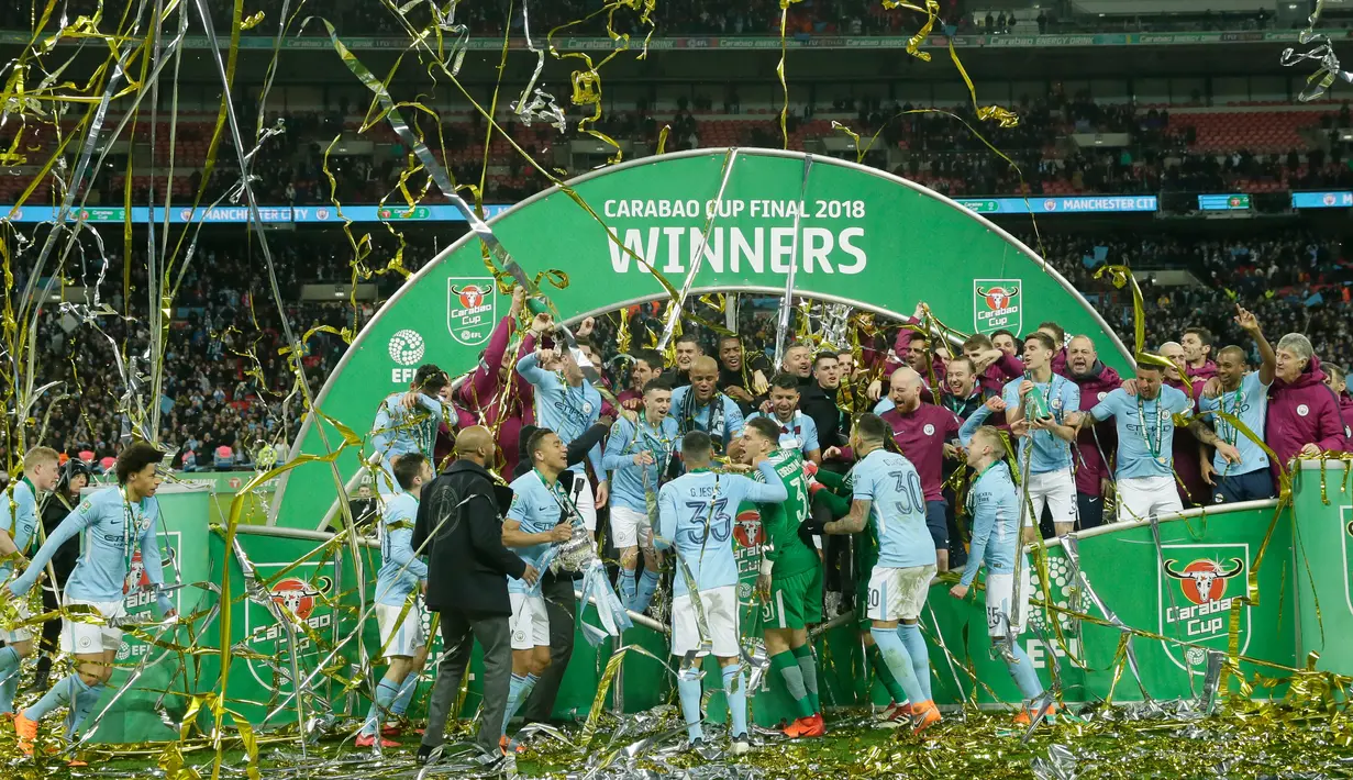 Para pemain Manchester City merayakan keberhasilan menjadi juara Piala Liga Inggris seusai mengalahkan Arsenal di Stadion Wembley, Minggu (25/2).Trofi ini sekaligus menjadi trofi pertama yang disumbangkan oleh sang manajer Pep Guardiola. (AP/Tim Ireland)