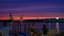 Seorang wanita berpose untuk foto di kawasan pejalan kaki pelabuhan di Osaka (20/9/2020).  Pelabuhan Osaka juga memiliki mitra kembar dengan Pelabuhan Busan. (AFP/Philip Fong)