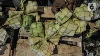 Aktivitas pedagang saat membuat bungkus atau tali ketupat di Pasar Klender, Jakarta Timur, Selasa (11/5/2021) malam. Biasanya empat hari menjelang Lebaran pedagang ketupat musiman tersebut mulai bermunculan menjajakan bahan baku makanan khas Idul Fitri ini. (merdeka.com/Iqbal S Nugroho)