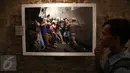 Pengunjung di depan sebuah foto saat pameran foto Anugerah Pewarta Foto Indonesia (APFI) ke-VI di Gedung De Vries, Bandung, Sabtu (9/4). APFI 2016 memamerkan 25 foto tunggal dan tiga foto seri terbaik sepanjang tahun 2015. (Liputan6.com/Faizal Fanani)