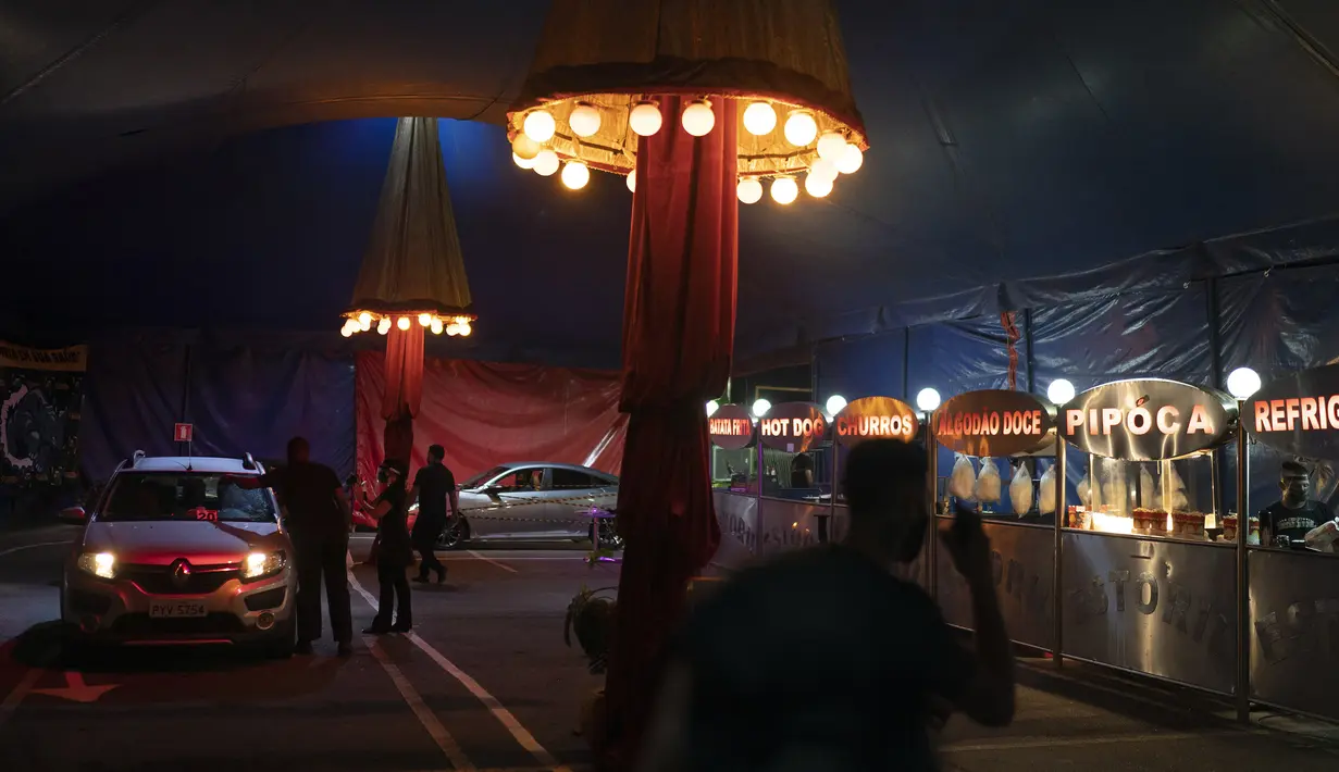 Penonton tiba mengendarai mobil saat akan menyaksikan pertunjukan Estoril Circus berformat drive-in di Itaguai, Rio de Janeiro, Brasil, Sabtu (18/7/2020). Pertunjukan yang berlangsung di tengah pandemi tersebut mengikuti langkah-langkah untuk mengekang penyebaran COVID-19. (AP Photo/Leo Correa)
