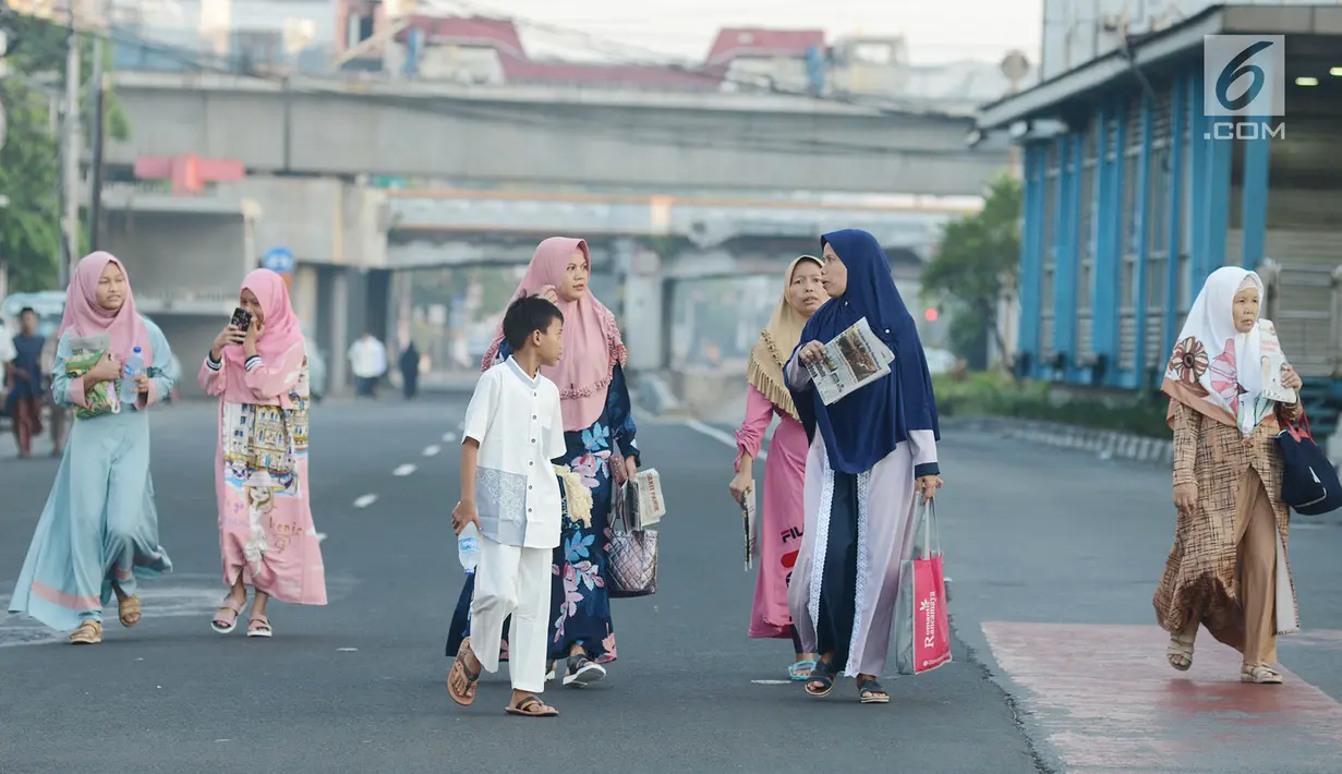 Umat muslim berjalan mendatangi lokasi pelaksanaan salat Idul Fitri 1 Syawal 1440 Hijriah di Jatinegara, Jakarta,Rabu (5/6/2019). Pelaksanaan salat Idul Fitri di lokasi ini diikuti oleh ribuan jemaah. (merdeka.com/Imam Buhori)