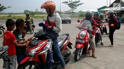 Anak - anak di SPBU Tanjung Pantura - Brebes membersihakan motor pemudik dari Jakarta menuju kampung halamannya, Kamis (22/6). Memanfaatkan moment mudik ini anak - anak pantura mengais rejeki untuk lebaran 1438 H. (Liputan6.com/Johan Tallo)