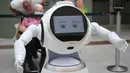 Para pengunjung mengamati sebuah robot pintar yang menjelaskan tentang langkah-langkah pencegahan COVID-19 di sebuah pusat perbelanjaan di Frankfurt, Jerman, pada 12 September 2020. (Xinhua/Lu Yang)