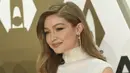 Gigi Hadid tersenyum saat tiba menghadiri CMA Awards tahunan ke-53 di Bridgestone Arena di Nashville, Tennessee (13/11/2019). Model berusia 24 tahun ini tampil memukau dalam balutan gaun putih. (AP Photo/Evan Agostini)