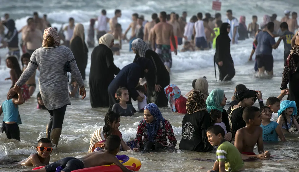 Warga Palestina menikmati liburan di pantai Tel Aviv, Israel, Minggu (19/7/2015). Selama Idul Fitri, pemerintah Israel mengizinkan warga Palestina untuk berwisata di sepanjang garis pantai Mediterania. (REUTERS/Baz Ratner)