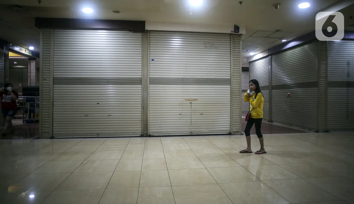 Seorang wanita berjalan di antara kios yang kosong di Mangga Dua Square, Jakarta, Senin (29/11/2021). Walau pemerintah sudah membolehkan warga beraktivitas di luar rumah, Mangga Dua Square yang beberapa tahun lalu merasakan masa kejayaan kini sepi dan banyak kios tutup. (Liputan6.com/Johan Tallo)
