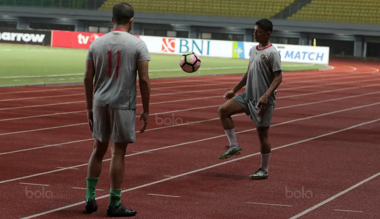 Dua pemain Bhayangkara FC melakukan pemanasan sebelum sesi latihan di Stadion Patriot Bekasi, Sabtu (11/11/2017). Latihan tersebut jelang melawan Persija. (Bola.com/Nicklas Hanoatubun)