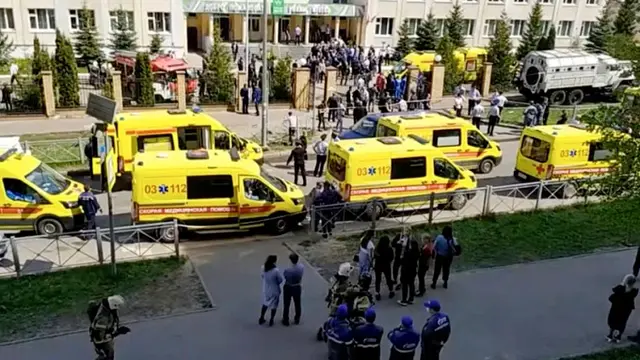 Ambulans dan truk polisi diparkir di sebuah sekolah setelah penembakan, di Kazan, Rusia, Selasa, 11 Mei 2021. Media Rusia melaporkan bahwa beberapa orang telah tewas dan terluka dalam penembakan di sekolah tersebut. (AP Photo)