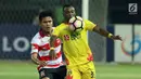 Penyerang Bhayangkara FC, Guy Junior Nke (kanan) berebut bola dengan pemain Madura United, Fachrudin dilanjutan Liga 1 Indonesia di Stadion Patriot Chandrabhaga, Bekasi, Kamis (13/7). Bhayangkara FC unggul 2-1. (Liputan6.com/Helmi Fithriansyah)