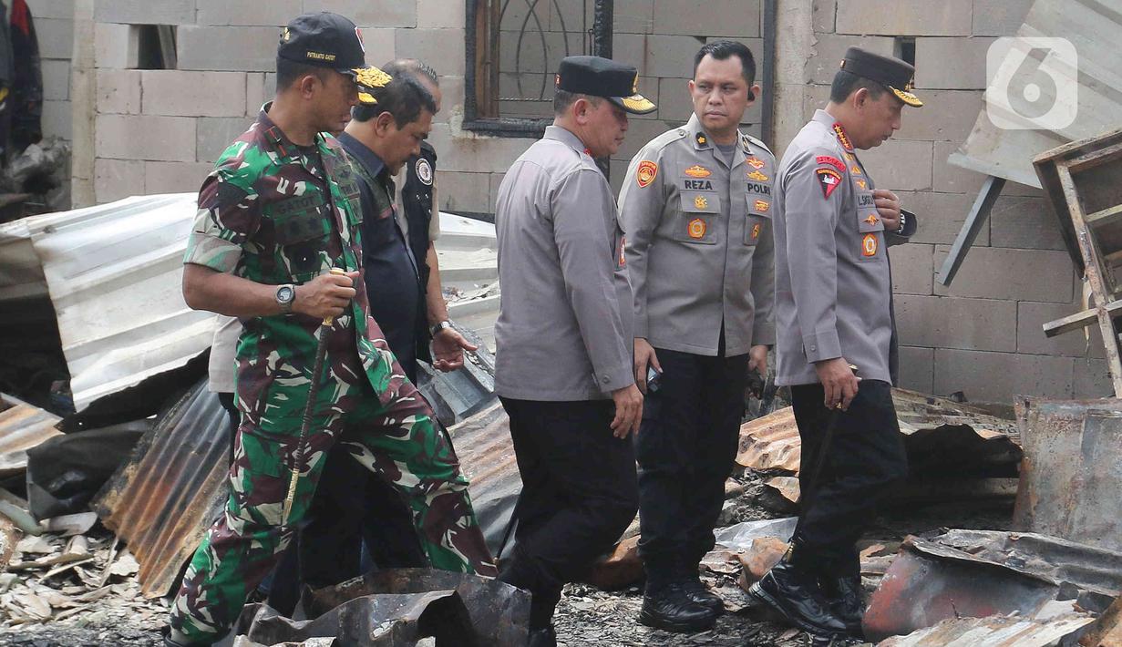 Kapolri Jenderal Listyo Sigit Prabowo (kanan) mendatangi langsung lokasi kebakaran Depo Pertamina Plumpang, Jakarta Utara, Sabtu (4/3/2023). Kapolri didampingi oleh Kabareskrim Komjen Agus Andrianto dan Kapolda Metro Jaya Irjen Fadil Imran untuk melihat dampak kebakaran. (Liputan6.com/Herman Zakharia)