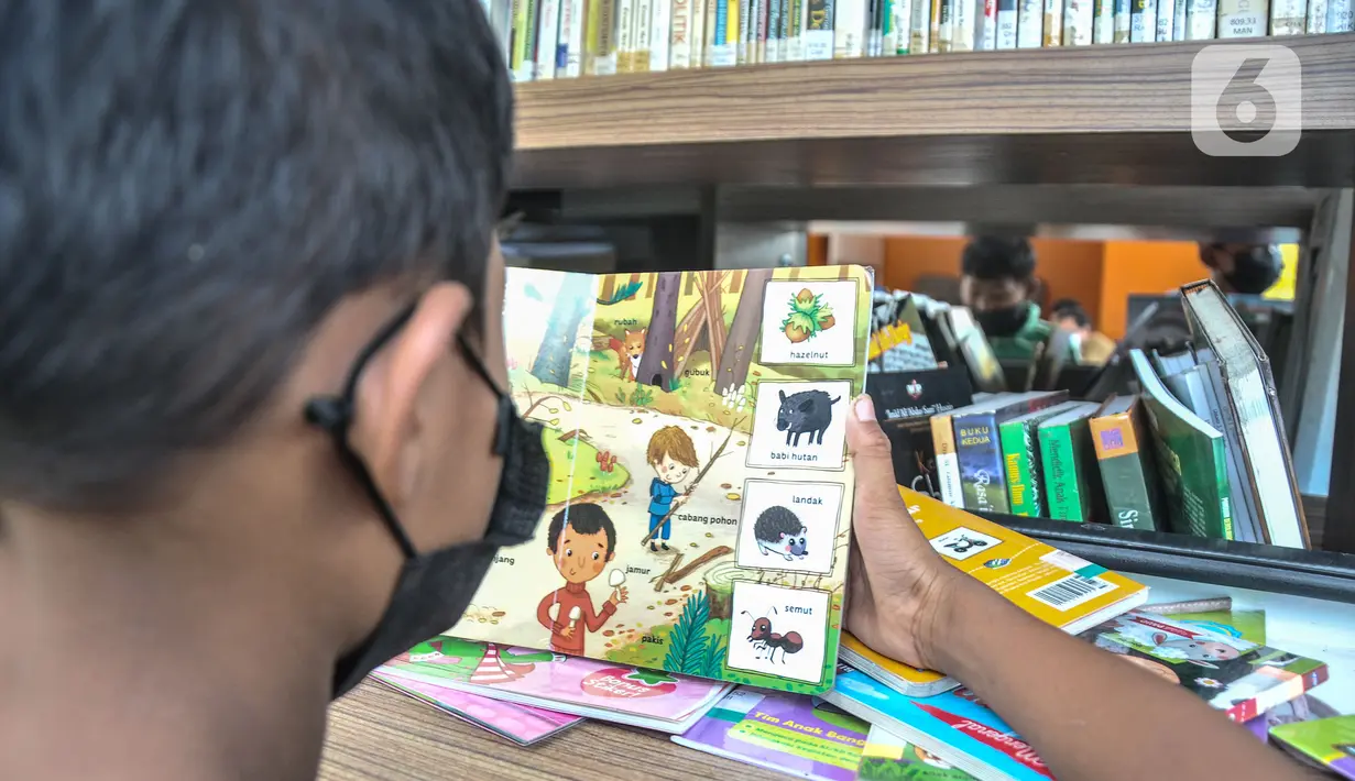 Seorang anak membaca buku di Perpustakaan Keliling kawasan Jatinegara, Jakarta, Rabu (29/9/2021). Mobil Perpustakaan Keliling yang difasilitasi Dinas Perpustakaan dan Kearsipan DKI itu merupakan sarana dan upaya pemerintah dalam meningkatkan minat baca anak sejak dini. (merdeka.com/Iqbal S Nugroho)