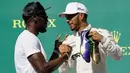 Pembalap Marcedes, Lewis Hamilton mendapat ucapan selamat dari mantan atlet lari cepat asal Jamaika, Usain Bolt di atas podium setelah berhasil memenangi balapan GP Amerika Serikat di Circuit of Americas, Minggu (22/10). (AP Photo / Tony Gutierrez)