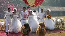 Empat pasangan pengantin berlari di antara sekumpulan hewan saat upacara pernikahan bersama di Ratchaburi, Thailand, Sabtu (13/2). Upacara pernikahan tersebut diikuti oleh empat pasang pengantin untuk menyambut Hari Valentine (REUTERS/Athit Perawongmetha)