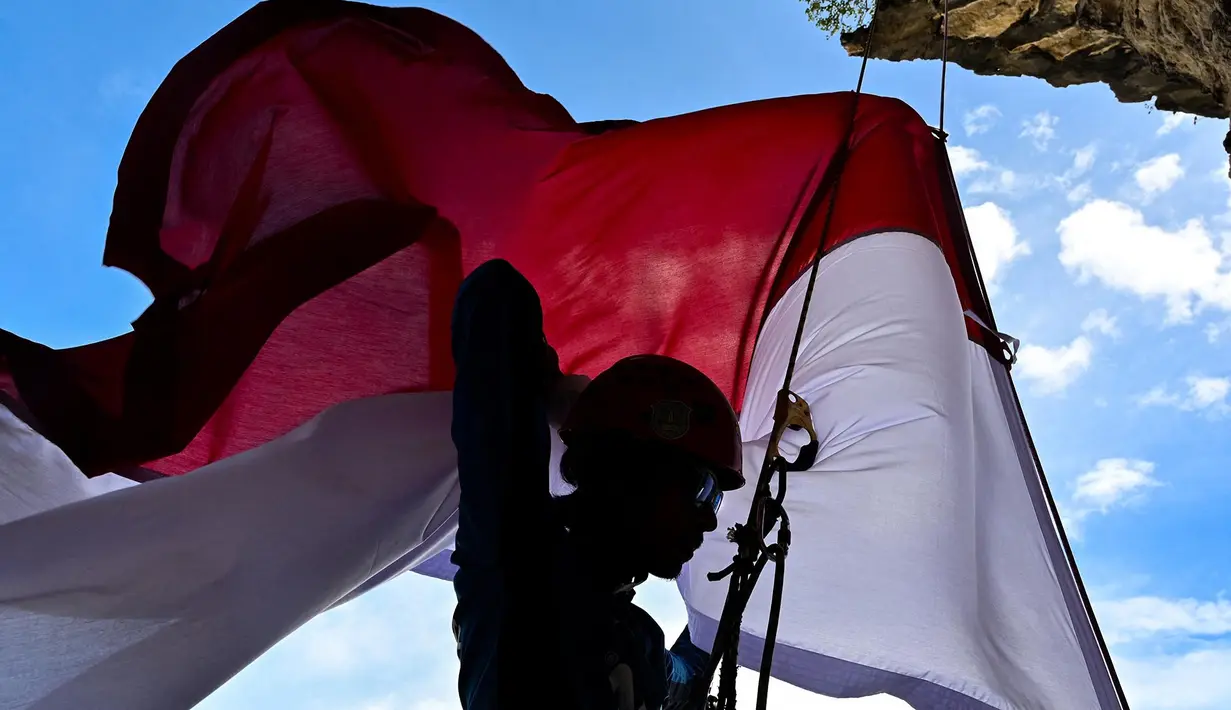 Seorang pemanjat menaiki  tebing saat pemasangan bendera merah putih pada tebing di Lhoknga, Aceh, Kamis,  13 Agustus 2026.