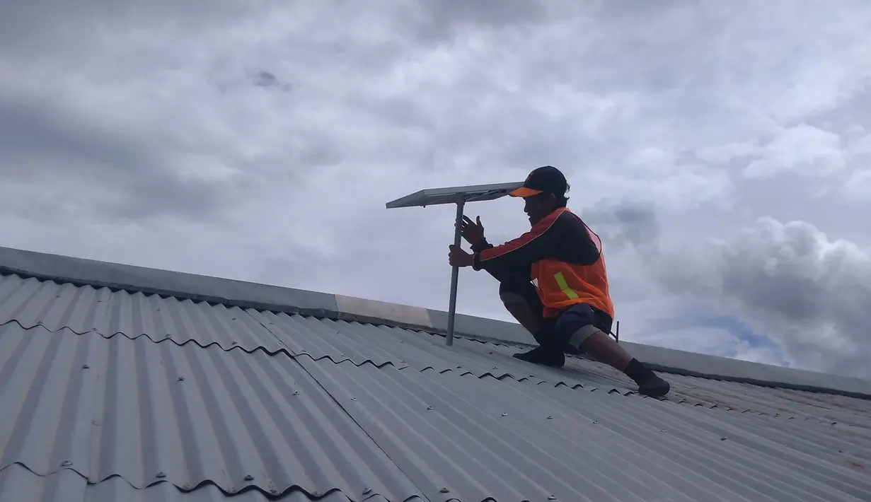 Petugas memasang Lampu Tenaga Surya Hemat Energi (LTSHE) di rumah penduduk di desa terpencil Papua. Pada 2017 Kementrian ESDM telah membagikan paket LTSHE untuk 79.564 rumah di 1.027 desa.  (Liputan6.com/HO/Hadi M Djuraid)