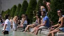 Sejumlah orang menyegarkan diri di air mancur Trocadero, Paris, sambil menikmati matahari musim panas, Senin (19/6). Suhu temperatur di ibu kota Prancis ini mencapai 36 derajat celcius. (AFP Photo / LUDOVIC MARIN)