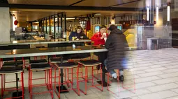 Sejumlah kecil pengunjung terlihat melalui jendela restoran McDonald's pada hari kerja terakhirnya di Pushkinskaya Square di Moskow, Rusia, Senin (14/3/2022). Gerai makanan cepat saji McDonald’s resmi menutup 850 gerainya yang beroperasi di Rusia pada 14 Maret 2022. (AP Photo)