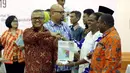 Ketua KPU Arief Budiman memberikan buku saat acara rapat Penyampaian Penetapan Daerah Pemilihan dan Alokasi Kursi Anggota DPRD Kab/Kota Pemilu 2019 di Kantor KPU Pusat, Jakarta, Rabu (18/4). (Liputan6.com/JohanTallo)