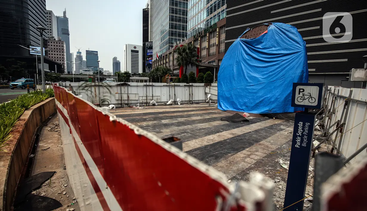 Suasana Proyek Pembangunan tugu sepeda di Jalan Jenderal Sudirman, Jakarta, Rabu (30/3/2022). Tugu yang dulu sempat boming dan digembar-gemborkan kini terlihat terhenti pengerjaannya dan hanya ditutup terpal. (Liputa6.com/Johan Tallo)