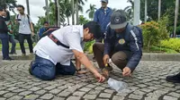 Tim asistensi Komisi Pengarah (komrah) kawasan Medan Merdeka mengambil sampel aspal yang diperuntukan lintasan Formula E, Rabu (26/2/2020). (Merdeka.com/ Yunita Amalia)