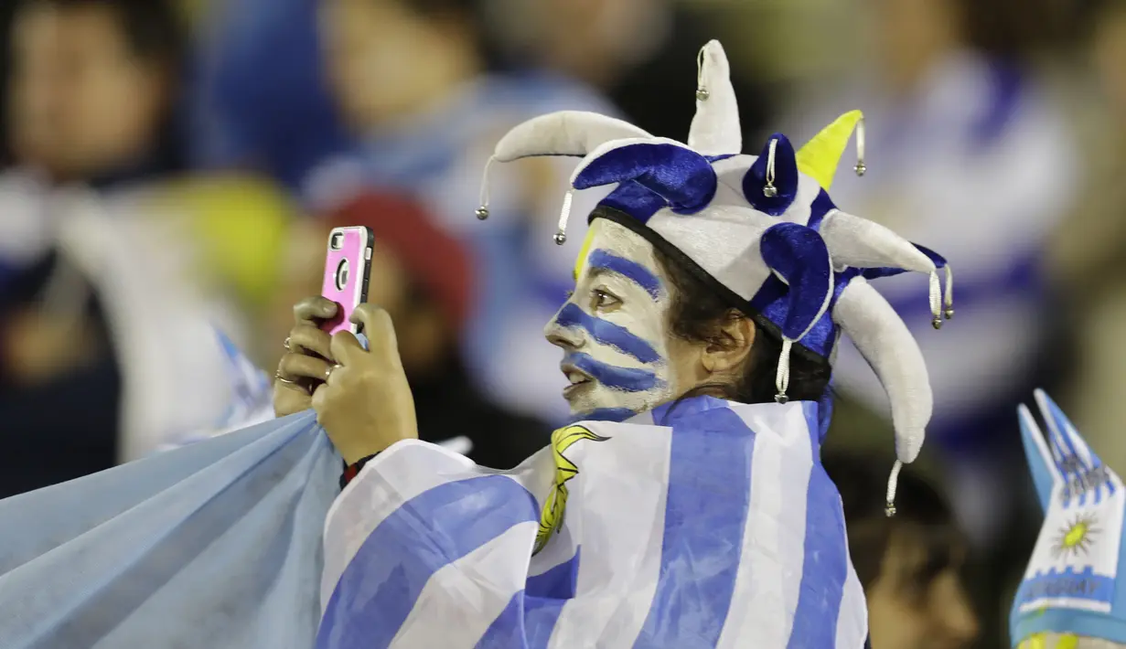Suporter Uruguay mengambil gambar dengan smartphone saat timnya melawan Argentina  pada laga kualifikasi Piala Dunia 2018 di Montevideo, Uruguay, (31/8/2017). Argentina bermain imbang 0-0. (AP/Natacha Pisarenko)