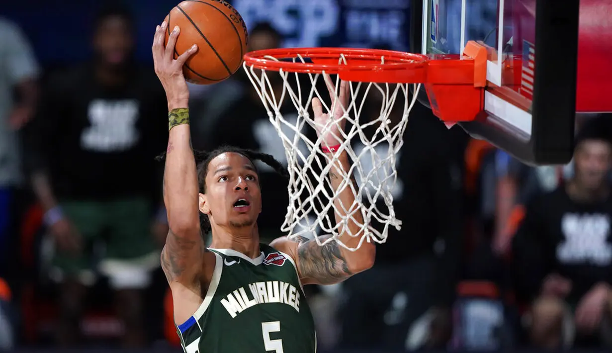 Pebasket Milwaukee Bucks, D.J. Wilson, memasukkan bola saat melawan Washington Wizards pada laga NBA, Selasa (11/8/2020). Bucks mengalahkan Wizards dengan skor 126-113. (AP Photo/Ashley Landis, Pool)