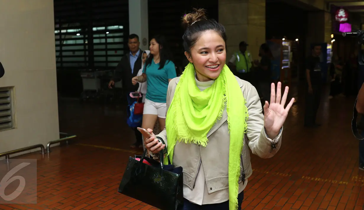 Penyanyi Marshanda melambaikan tangan saat tiba di Terminal 2 Bandara Soekarno Hatta, Tangerang, Senin (23/1). Marshanda menjelaskan kondisi ayahnya yang saat ini berada di Pesantren Bahrul Maghfiroh, Malang. (Liputan6.com/Herman Zakharia)