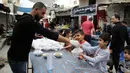 Para pekerja Palestina membagikan makanan gratis pada hari keempat Ramadan di Deir al-Balah, Jalur Gaza tengah, pada 27 April 2020. (Xinhua/Rizek Abdeljawad)