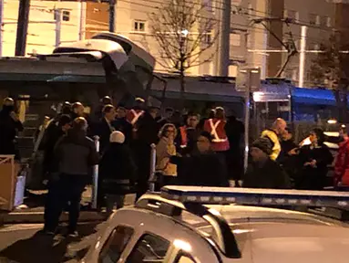 Personel layanan darurat berkumpul di lokasi tabrakan antara dua rangkaian trem di wilayah Issy-les-Moulineaux, Paris, Senin (11/2). Kecelakaan langka yang terjadi di pinggiran barat daya Paris itu mengakibatkan 12 orang terluka. (Philippe DUPEYRAT / AFP)