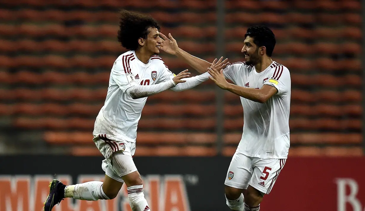 Pemain UEA, Omar Abdulrahman (kiri), merayakan gol yang dicetaknya ke gawang Malaysia dalam Kualifikasi Piala Dunia 2018 di Stadion Shah Alam, Malaysia, (17/11/2015). Malaysia kalah 1-2 dari UEA. (AFP Photo/Manan Vatsyayana)