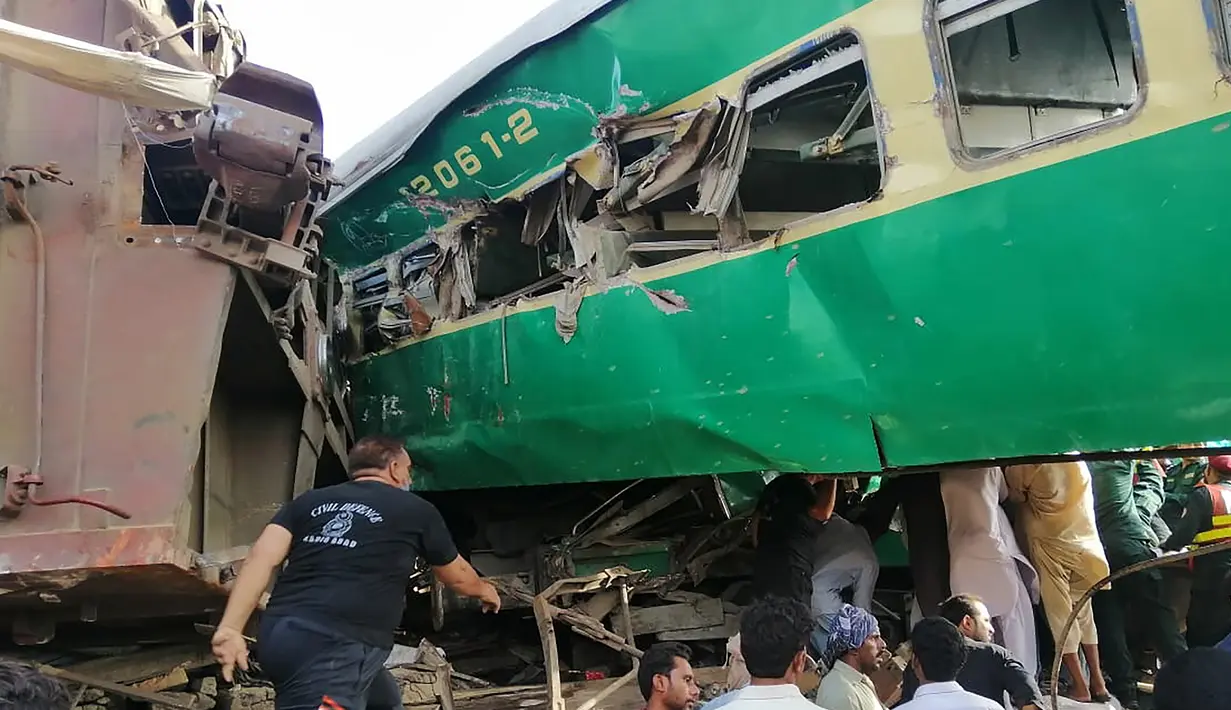 Tim penyelamat dan penduduk setempat berkumpul di dekat kecelakaan yang terjadi antara dua kereta di distrik Rahim Yar Khan, Pakistan, Kamis (11/7/2019). Insiden ini menyebabkan setidaknya sembilan orang tewas dan lebih dari 60 lainnya luka-luka. (Photo by STR / AFP)