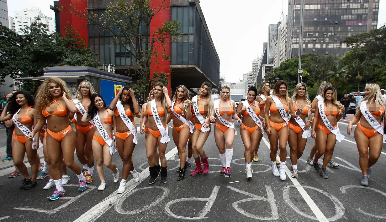 Sejumlah wanita seksi menyusuri jalanan di Sao Paulo, Senin (8/8). Mengenakan bikini, para wanita tersebut mempromosikan kontes Miss BumBum 2016 yaitu kontes yang menganugerahi wanita dengan pantat terindah seantero Brasil. (Miguel SCHINCARIOL/AFP)
