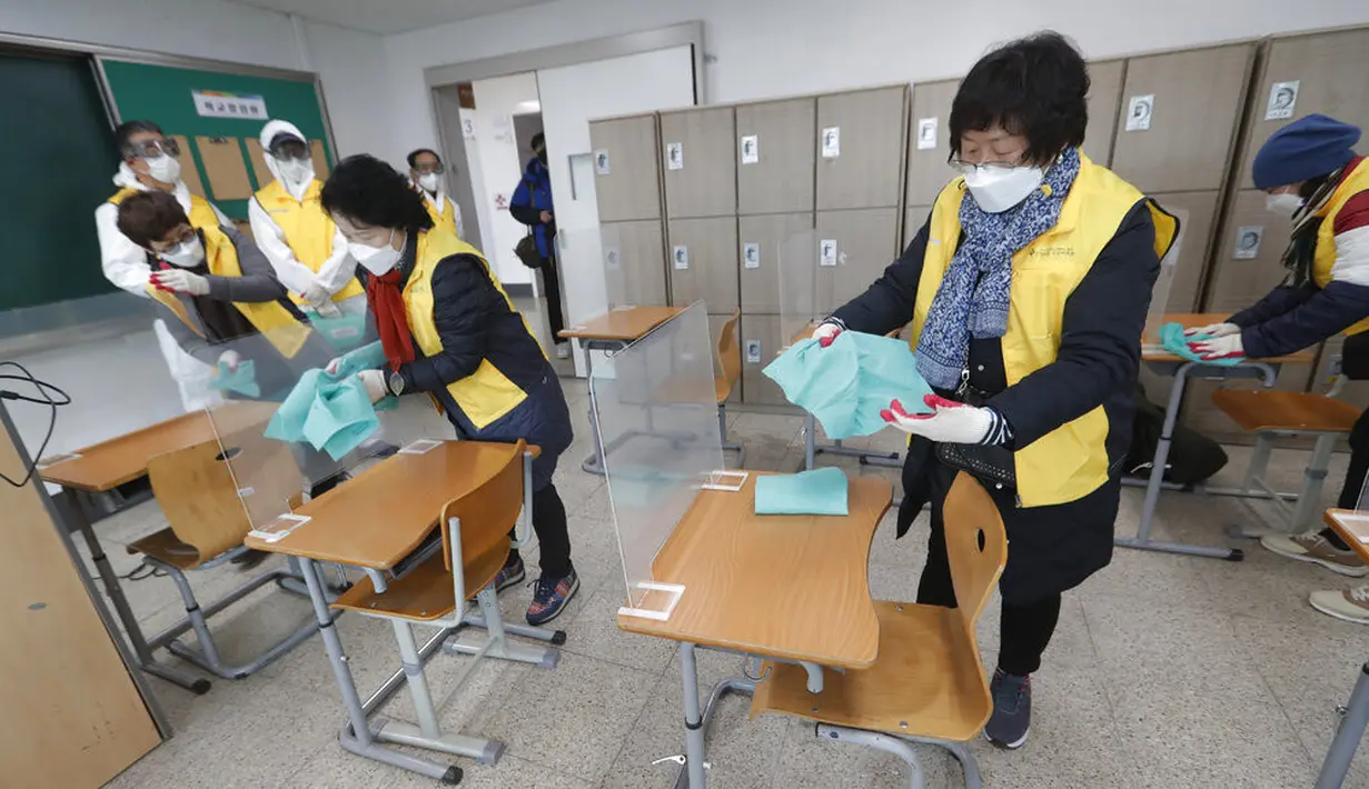 Petugas mendisinfeksi meja untuk ujian masuk perguruan tinggi di Seoul, Korea Selatan, Selasa (1/12/2020). Sekitar 490.000 siswa lulusan sekolah menengah atas di Korea Selatan akan menjalani Tes Kemampuan Skolastik Perguruan Tinggi pada 3 Desember 2020. (AP Photo/Ahn Young-joon)