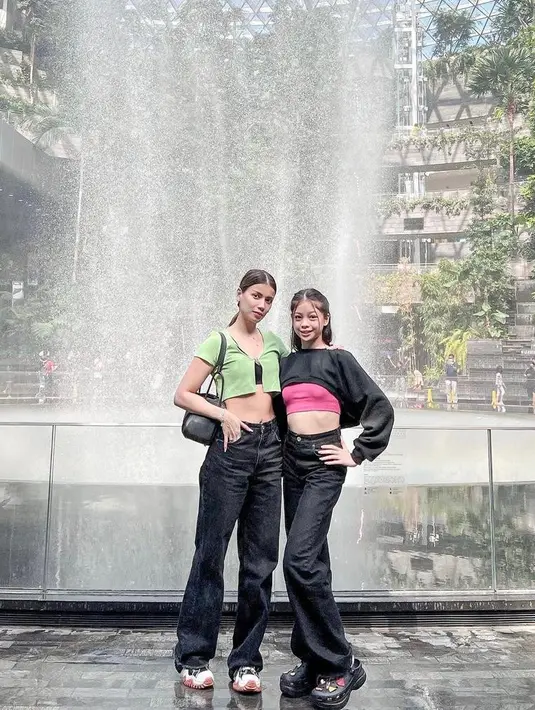 Kala liburan bareng di Singapura, Sabrina dan Nada kompak padukan black high waisted jeans dengan crop top. Gaya keduanya edgy abis! @sabrinachairunnisa_.