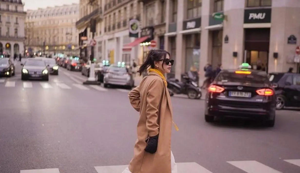 Begini style casual Wendy melawan hawa dingin di Paris. Istri Reza Arap itu memadukan long coat, trousers putih, dan sepatu sneakers. (Instagram/wendywalters).