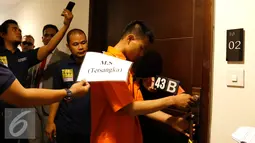 Tersangka Mursalim saat memperagakan 82 adegan dalam rekonstruksi yang digelar, Jakarta, Senin (14/9/2015). Mursalim terus tertunduk saat rekonstruksi tersebut. (Liputan6.com/Yoppy Renato)