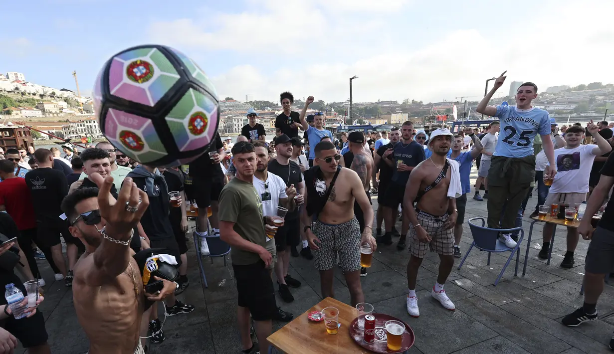 Pendukung Manchester City minum dan bernyanyi di tengah asap biru bom asap di tepi sungai Douro di Porto, Portugal (28/5/2021).  (AP Photo/Luis Vieira)