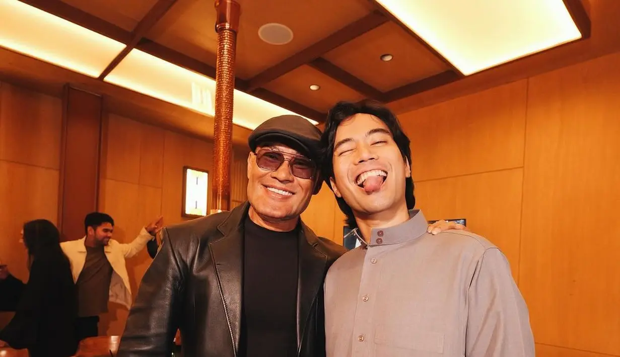 Gaya keren serba hitam Deddy Corbuzier, kenakan jas kulit, kaus, long pants, dan topi baret andalannya. [@mastercorbuzier]