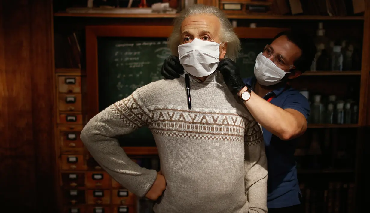 Seorang pekerja mengenakan makser pada patung lilin sosok Albert Einstein di Madame Tussauds di Istanbul, Sabtu (11/7/2020). Dibuka kembali, sejumlah sosok tokoh terkenal di museum itu dipakaikan masker untuk meningkatkan kesadaran terhadap penyebaran Covid-19. (AP Photo/Emrah Gurel)