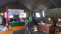 Salah satu pelanggar PPKM Darurat tengah mengikuti jalannya sidang Tipiring di tenda Posko penegakan hukum PPKM Darurat di bilangan Simpang Lima, Garut, Jawa Barat. (Liputan6.com/Jayadi Supriadin)