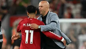 Pelatih Liverpool asal Belanda, Arne Slot, memeluk striker Mesir nomor punggung 11, Mohamed Salah, setelah pertandingan Premier League Inggris antara Liverpool dan Bournemouth di Anfield, Liverpool, Inggris barat laut, pada 15 Agustus 2025. Liverpool menang dengan skor 4-2. (Paul ELLIS/AFP)
