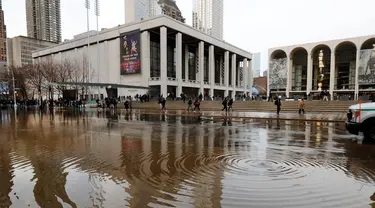 Banjir menggenangi jalanan dekat Lincoln Center for the Performing Arts di New York, Amerika Serikat, Senin (13/1/2020). Banjir diakibatkan rusaknya saluran air utama yang berdiameter tiga kaki. (AP Photo/Richard Drew)