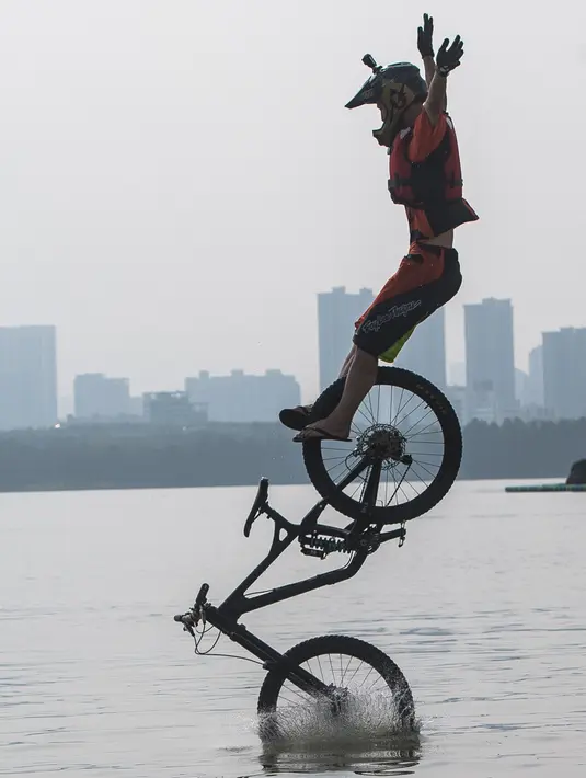 Seorang pesepeda melompat ke Danau Timur menggunakan sepeda BMX dalam ajang tahunan festival lompat air (water jump) BMX di Wuhan, ibu kota Provinsi Hubei, China tengah, pada 22 Agustus 2020. (Xinhua/Xiao Yijiu)