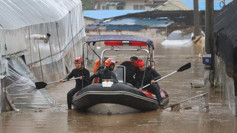 Petugas penyelamat di perahu membantu mengevakuasi warga desa yang banjir di Daejeon akibat hujan lebat, Rabu (10/7/2024). (Yonhap)