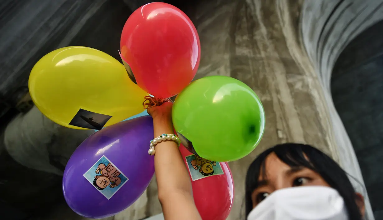 Seorang pelajar memegang balon saat melakukan demonstrasi menentang pembelian kapal selam oleh pemerintah yang berpihak pada militer di Bangkok (31/8/2020). (AFP/Lillian Suwanrumpha)