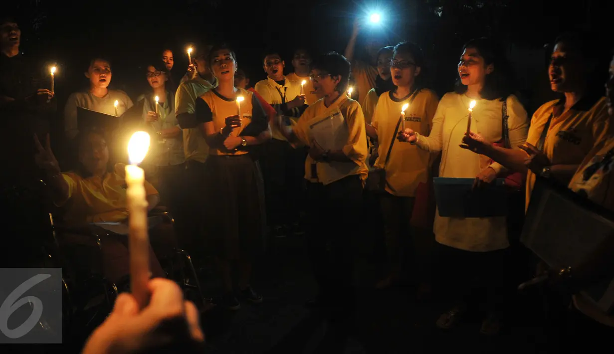 Sejumlah karyawan Artha Graha berkumpul sambil memegang lilin pada peringatan Hari Bumi atau Earth Hour di kawasan SCBD Jakarta saat lampu-lampu di kawasan itu mulai dipadamkan selama satu jam pada Sabtu malam (19/3/2016). (Foto: Istimewa)